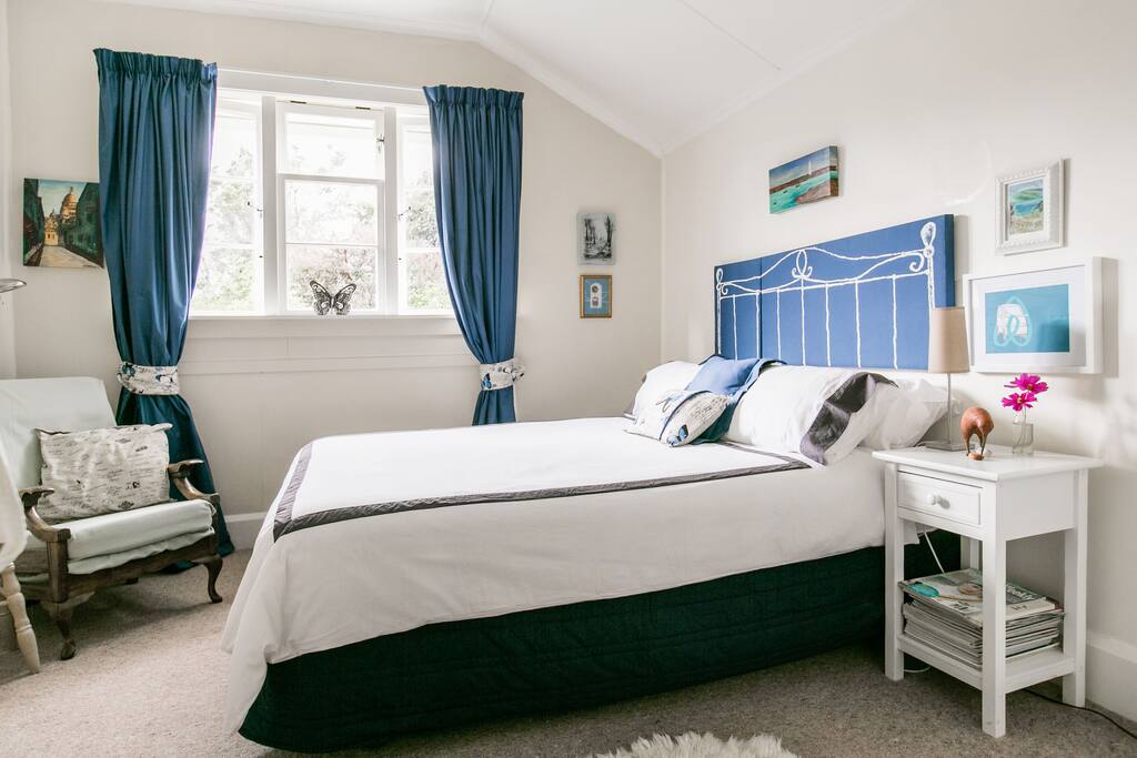 The spacious guest bedroom with comfortable chair to read and relax in.