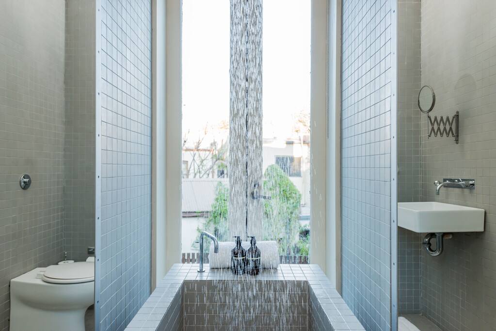 A fusion-bathroom featuring French doors and a Japanese-style tub