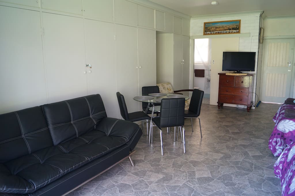 Looking into your room with sofabed/lounge and table with four chairs.