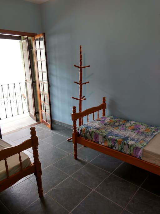 Quarto com duas camas de solteiro e sacada