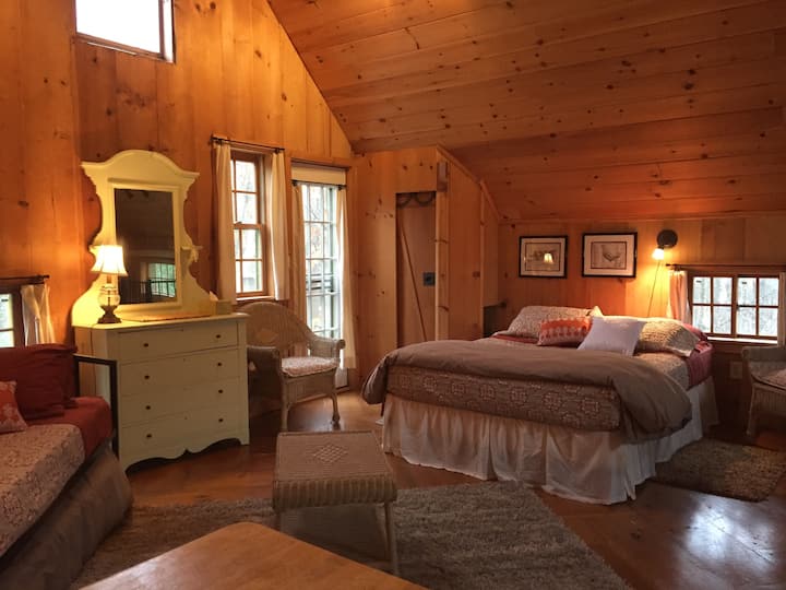 The loft bedroom with a queen and twin trundle bed. The door leads out to the back deck.
