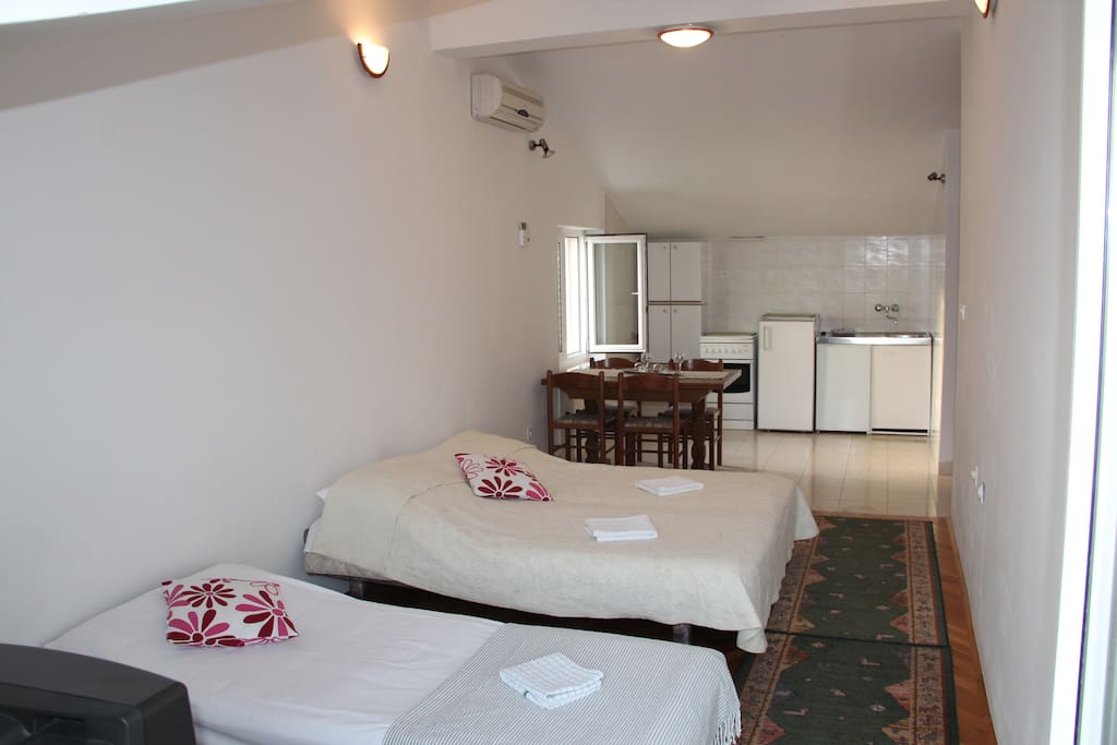 Living room with couch that converts in to beds, with connection to the kitchen