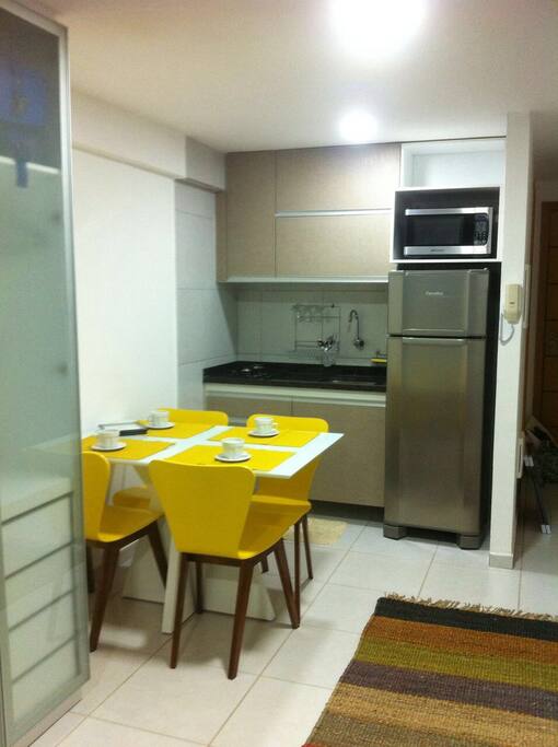 Cozinha completa. Geladeira, fogão, microondas, cafeteira, liquidificador, louça completa e panelas.