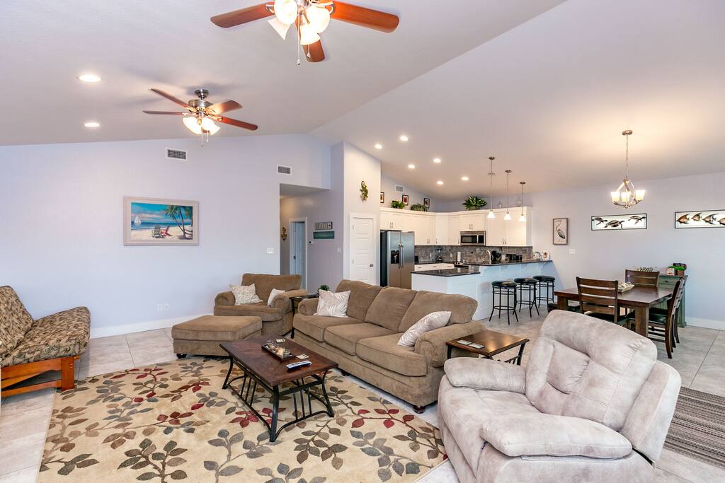 In the living room, a couch, 2 chairs, and 2 futons provide ample seating