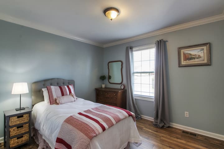 This room offers a twin bed with vintage tiger wood dresser and mirror along with a walk-in closet.