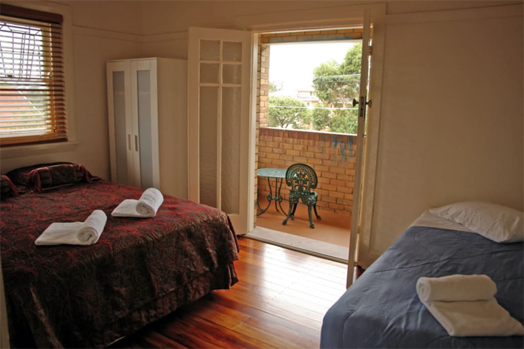 Main bedroom with queen and single beds plus balcony