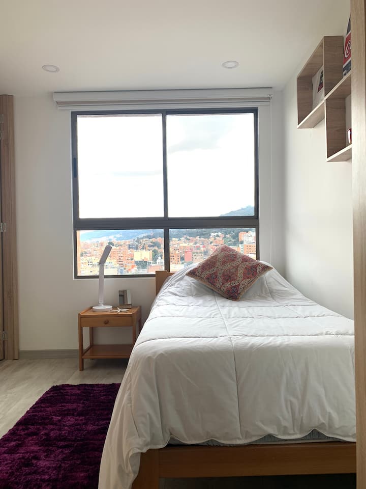 第二间温馨的房间配有单人床、大衣橱、共用美式卫生间和壮观的城市景观。