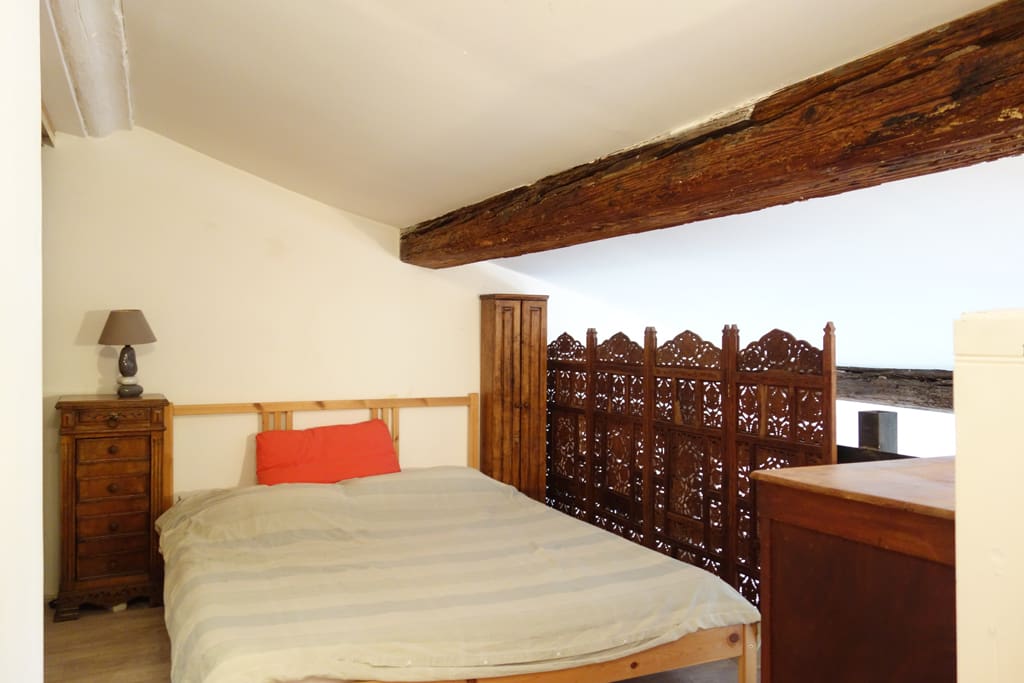 Au-dessus, la chambre se révèle en toute intimité.