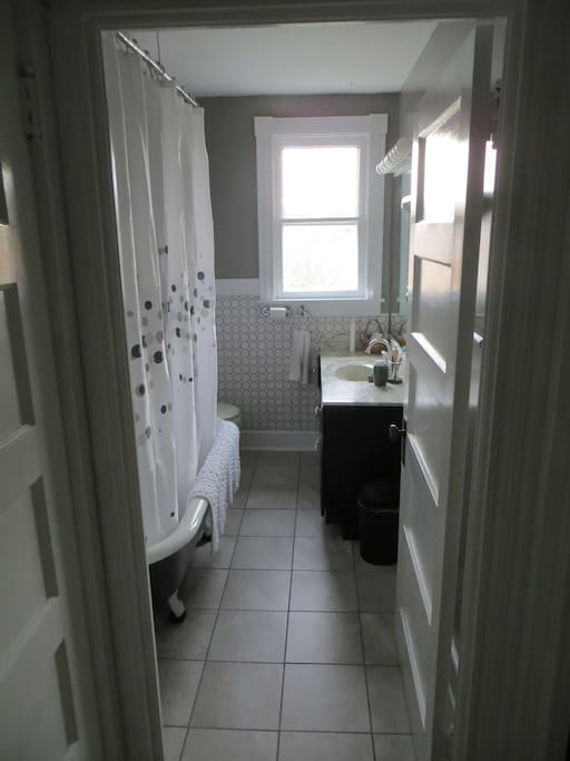 Recently renovated bathroom with clawfoot tub/shower adjacent to the bedroom.