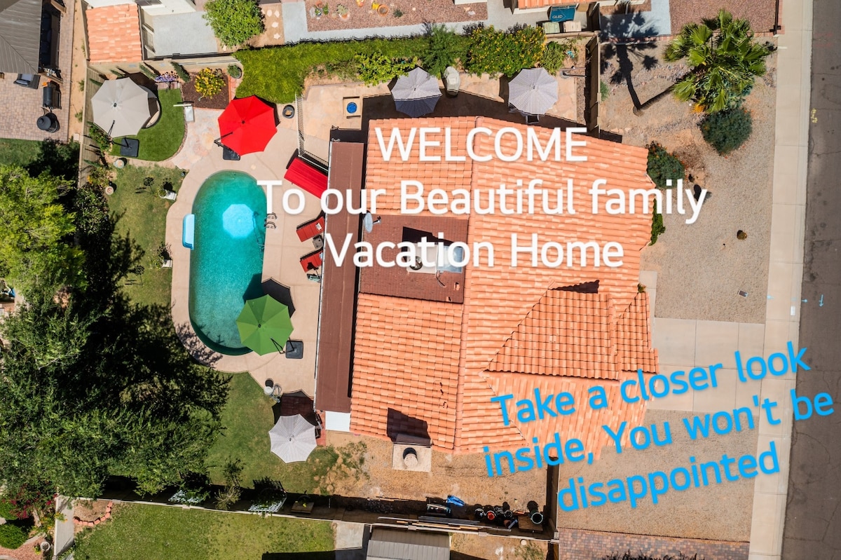 An aerial view captures a spacious property featuring a inviting swimming pool surrounded by lounge chairs and vibrant umbrellas. The home showcases a terracotta roof and well-maintained landscaping, emphasizing both relaxation and comfort in the backyard.