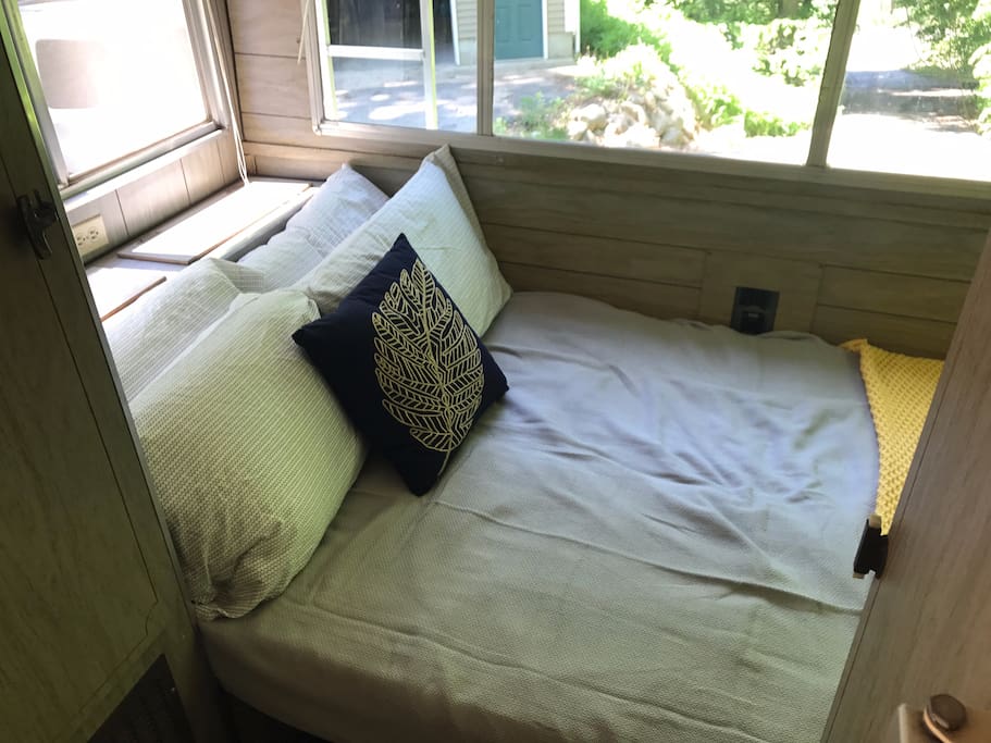 The "bedroom" with four cozy pillows, sheets, blankets and a throw. Head board includes outlet for phone and all windows include privacy blinds. The bedroom also has a closet for your belongings and a linen closet with toiletries, towels and games.