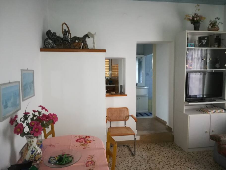 Living room with two three seater sofas, dining table, large tv and sound system