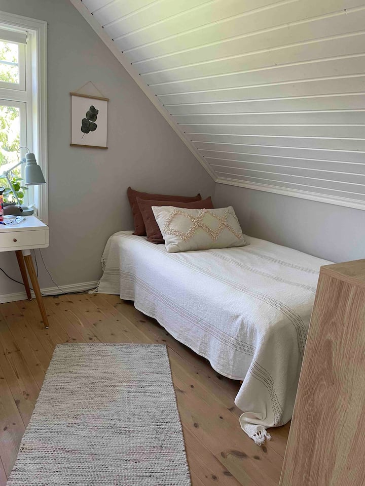 Dormitorio con cama de 120 cm y un escritorio Ventana al jardín y al campo.