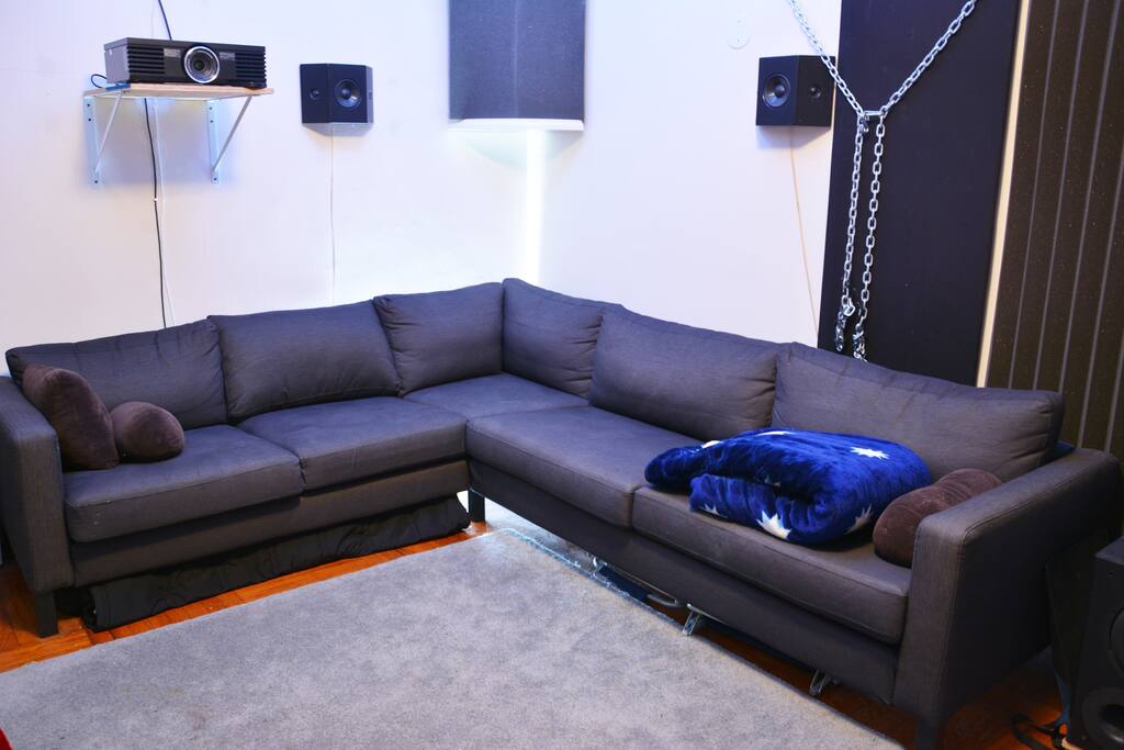 L-shaped Couch #1, soundproofing, surround sound speakers, and projector