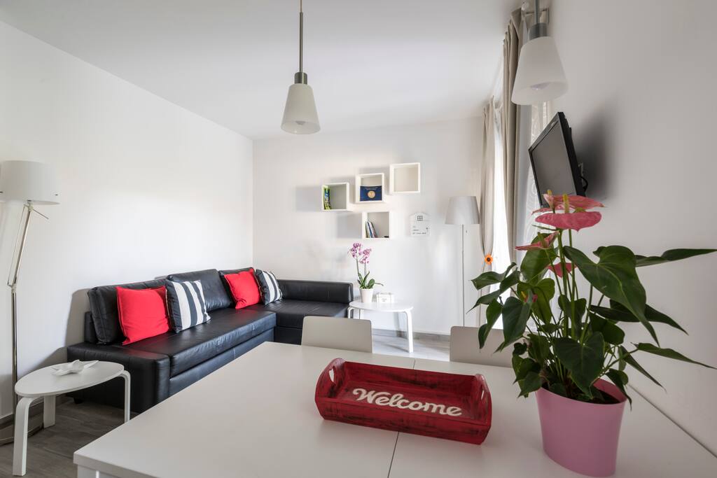 Living room with sofa bed and table with chairs/ soggiorno con divano letto matrimoniale, tavolo e sedie