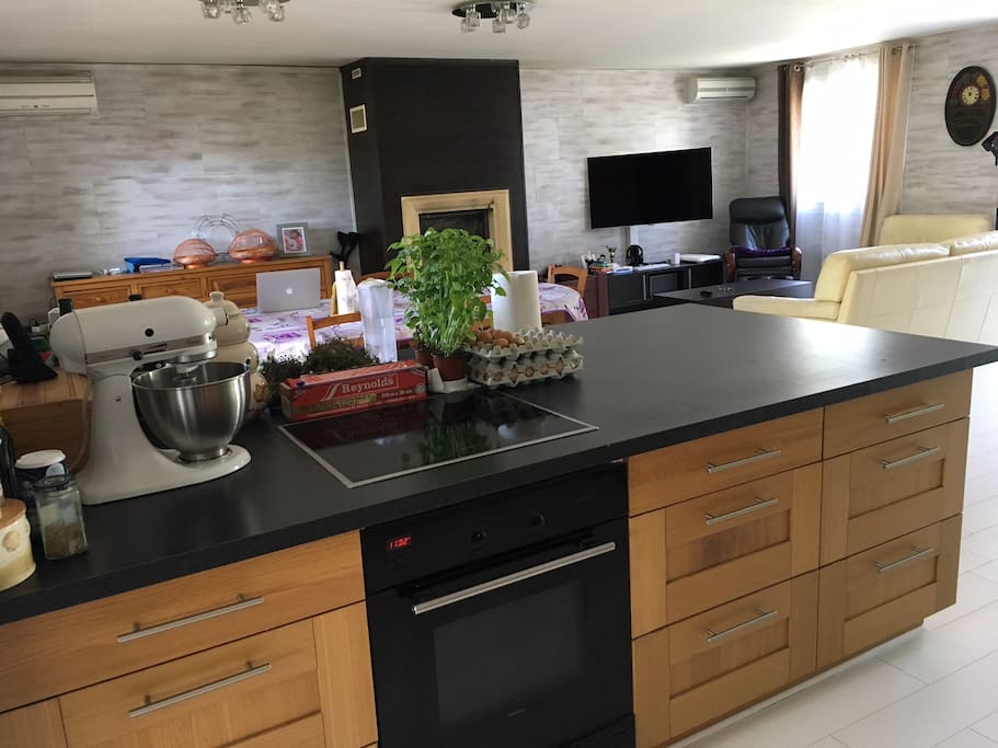 Salon spécieux accolé à une cuisine ouverte, accessibles aux visiteurs