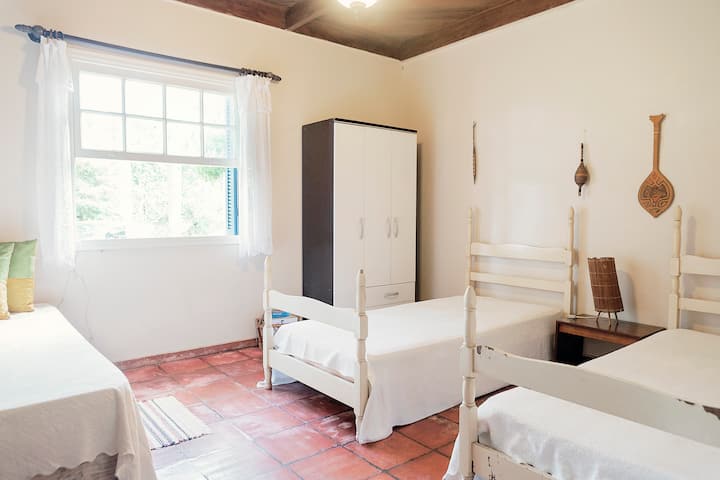 ห้องพักพร้อมเตียง 3 เตียงและฟูกนอนหันหน้าไปทางสระว่ายน้ำ