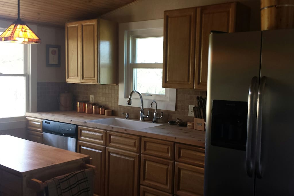Remodeled kitchen with refrigerator, garbage disposal, dishwasher, stove and oven, microwave, pantry, coffeemaker, and toaster.