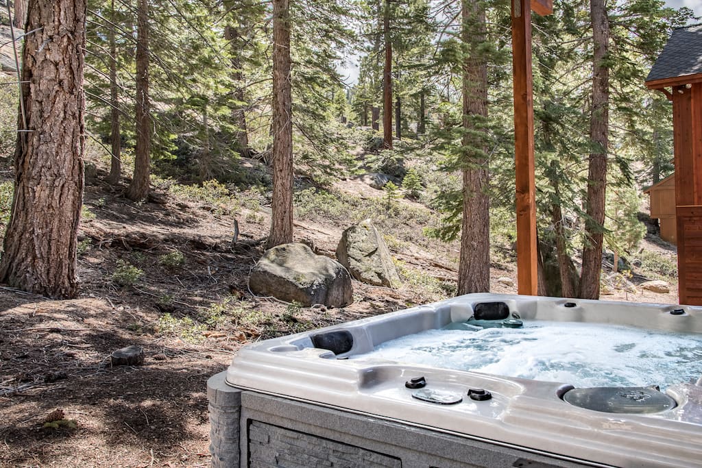 Soak in the bubbles beside the forested hillside.