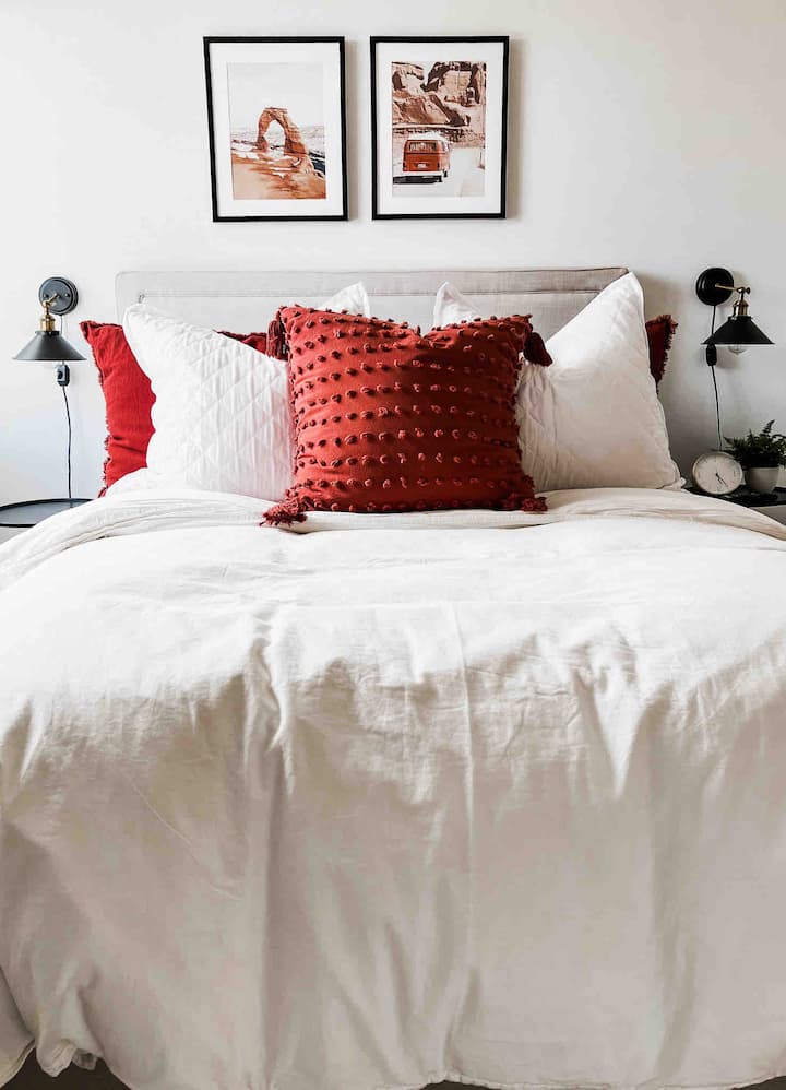 Cama tamaño queen con un montón de mantas y almohadas adicionales con colchón y protectores de almohadas y persianas protectoras de ruido y luz. 