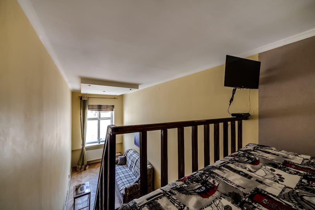 View of the room with sofa from the entresol where the mattress bed and TV are located