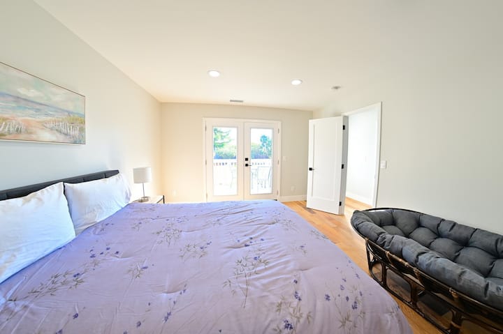 Თანამედროვე და ფართო მთავარი საძინებელი საწოლით და მყუდრო დასაჯდომი ადგილით