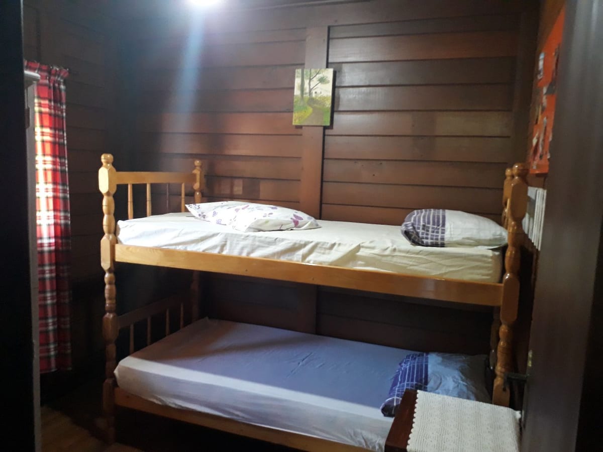 Ერთადგილიანი საძინებელი ხის ორსართულიანი საწოლით და გარდერობით.