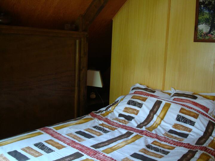 Spálňa rodičov. Priamo pred posteľou, oknom a jeho zeleným závesom