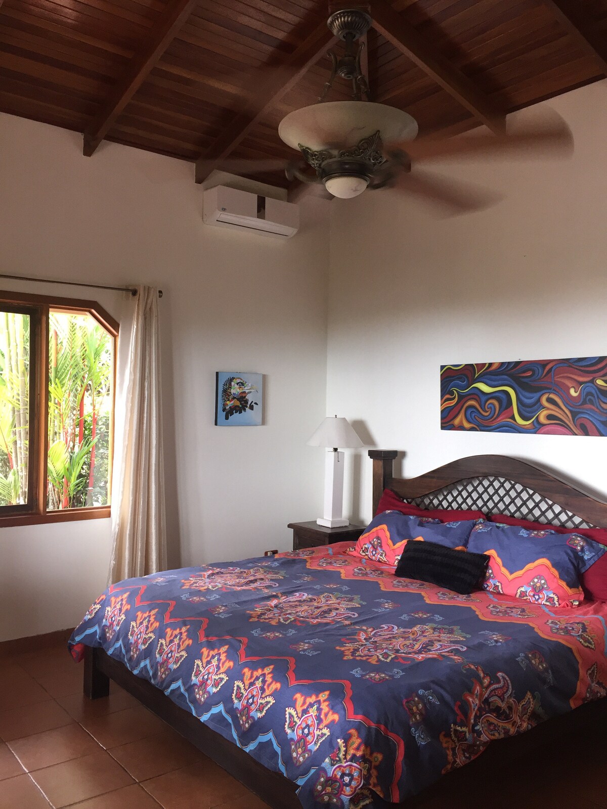 chumba kikubwa cha kulala kilicho na kitanda aina ya king, ac, feni na bafu lililounganishwa. 