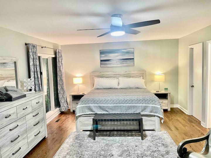Amplio dormitorio principal con cama tamaño king, balcón privado en un entorno boscoso tranquilo y vistas estacionales del lago Lure. Muebles nuevos (abril de 2023): colchón, mesitas de noche, cómoda, centro de entretenimiento y TV de 55pulgadas, pisos de madera nuevos.