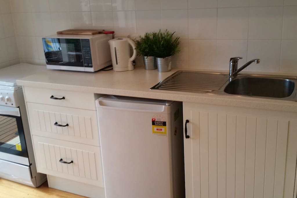 Kitchen has full size oven and stovetop microwave, kettle , toaster