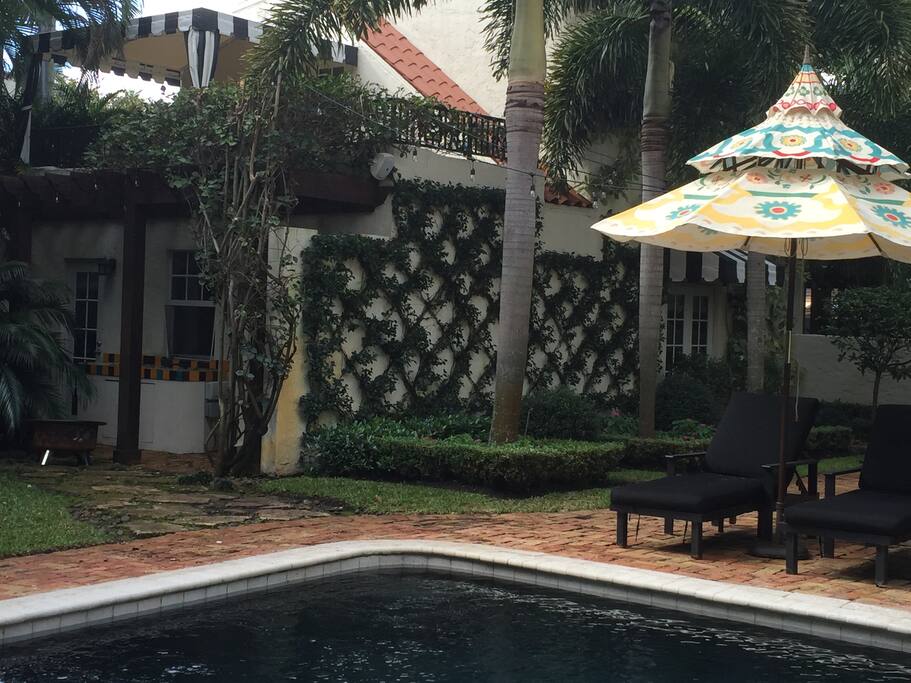 View of cottage and upstairs porch from across the pool.
