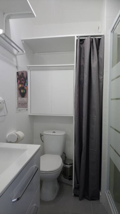 Salle d'eau avec une douche et plusieurs étagères pour le rangement