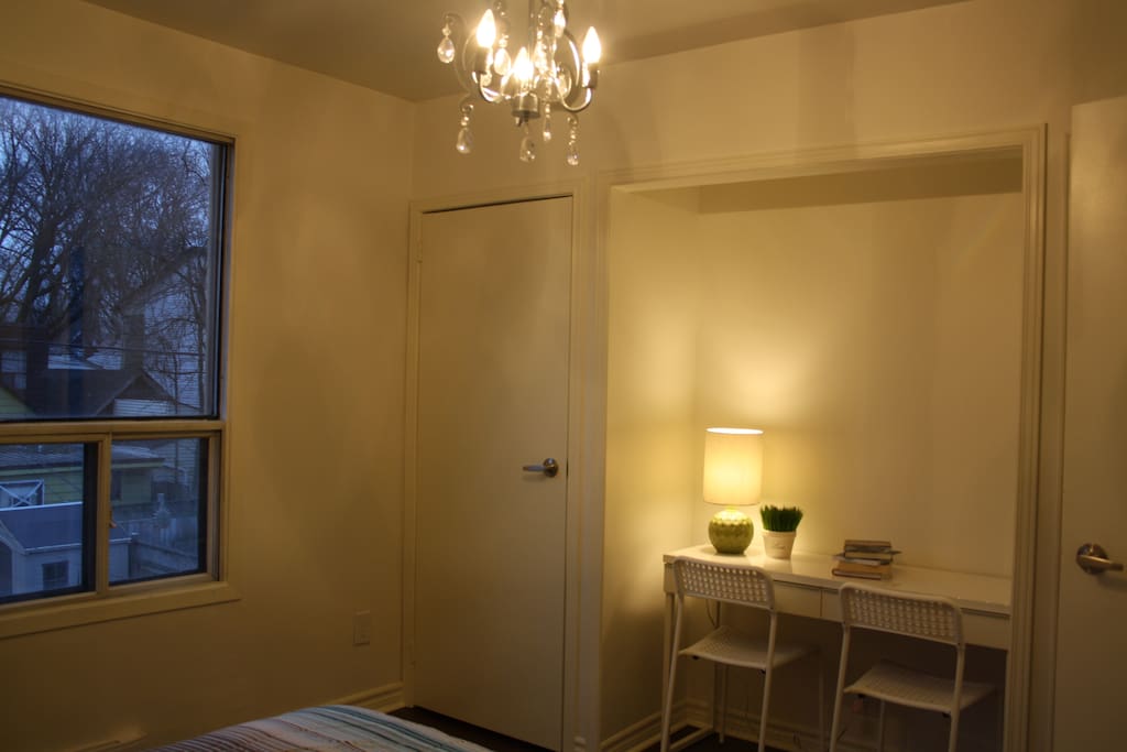 Bedroom with chandelier, closets, study table and comfy bed! (blinds missing in pic)