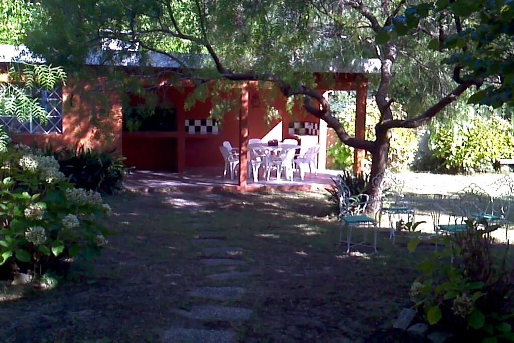 Fondo arbolado con parrillero techado y mesa para 8 personas