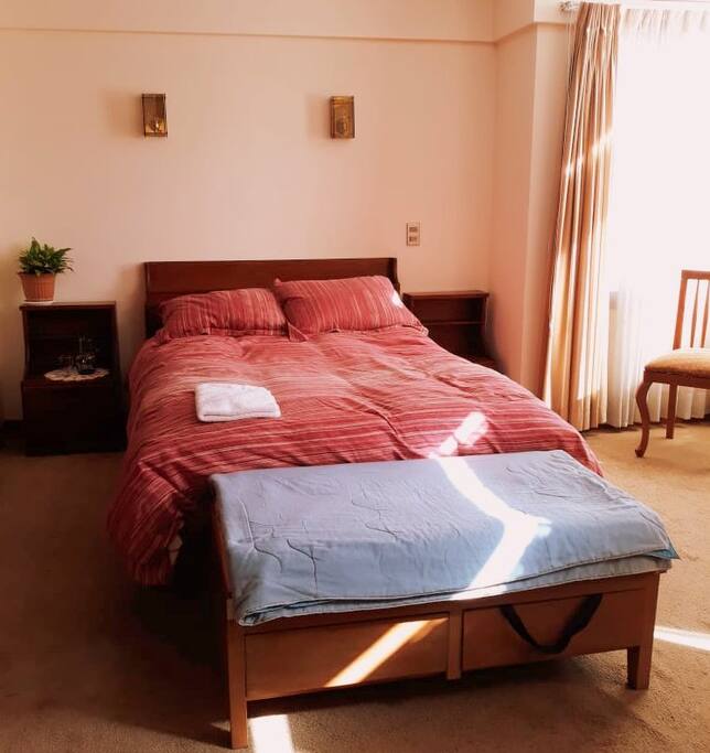 La habitación cuenta con una cama matrimonial y es llena de sol.
