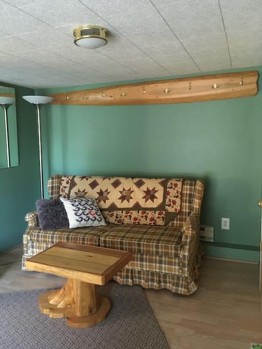Pull out couch in the living room looks out to a sliding door and private deck.