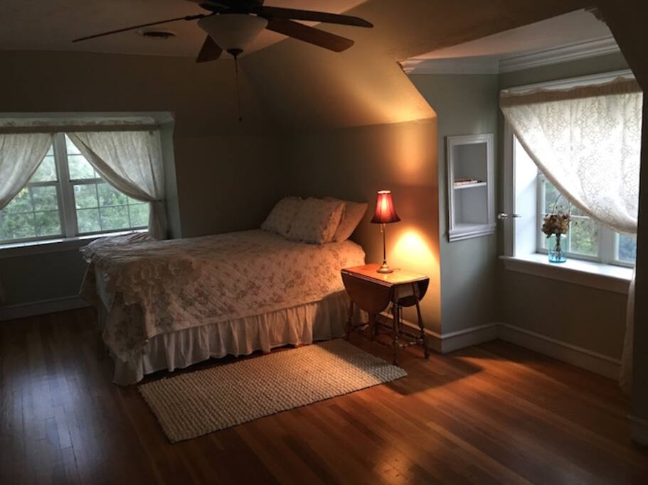 Large bedroom with comfy bed and lots of natural light.