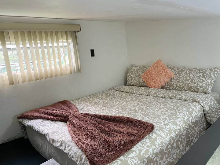 Cama tamaño queen en una habitación loft con hermosas vistas