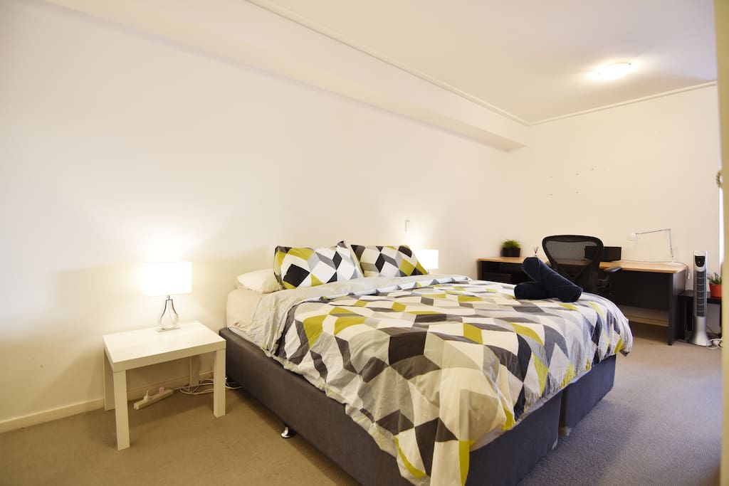 A bedroom area with a king sized bed & plush pillows.
