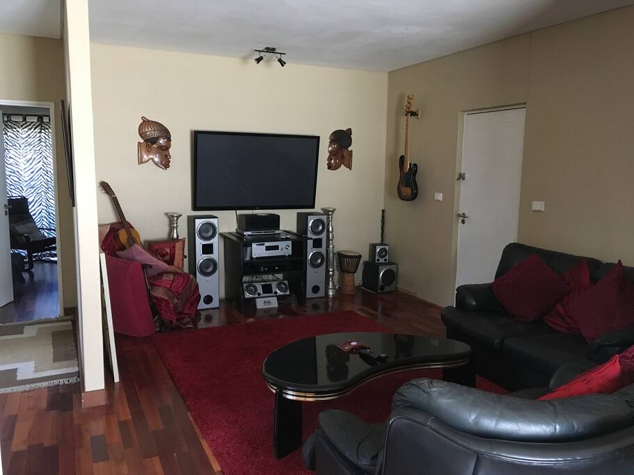 Spacious lounge with extra large TV - entrance to the bedroom on the left