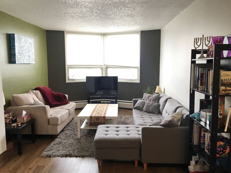 Comfy common area with wonderful city heart view and lots of natural light. For a cozy, more spacious stay, we have upgraded to an L-shaped sofa for a 3rd guest to sleep.