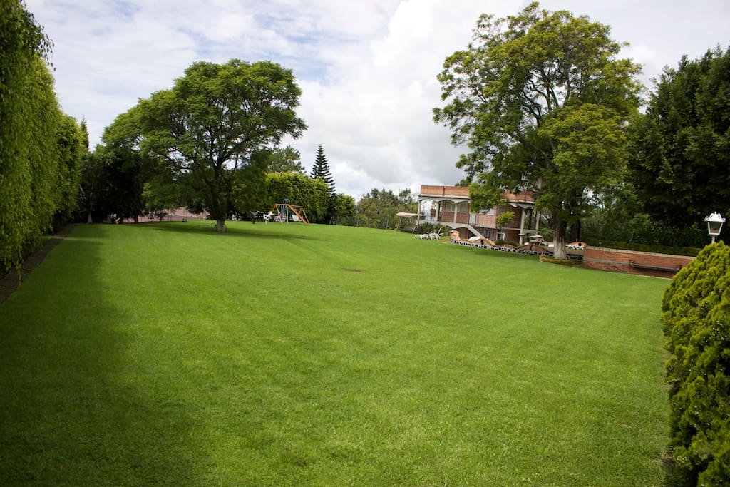Mantenemos nuestros hermosos jardines en excelente estado. Al fondo se puede apreciar el área de juegos infantiles.