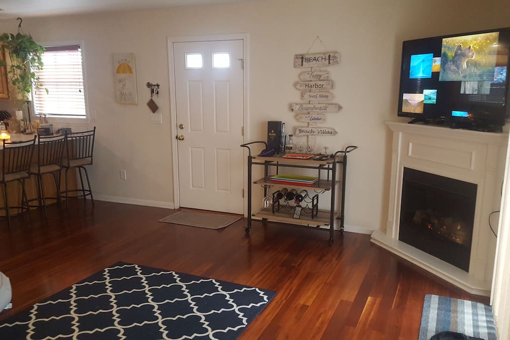 Shared living room, complete with Bar, 55in TV, and Fireplace. Deck access from off to the right and kitchen access to the left.