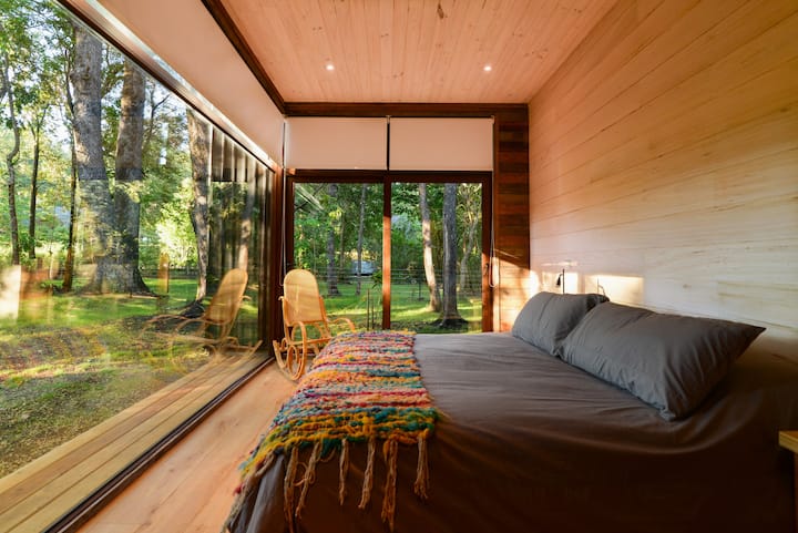 El dormitorio principal cuenta con un gran ventanal que encuadra una gran vista apaisada del entorno.
El dormitorio principal tiene una gran ventana que enmarca una gran vista paisajística de los alrededores.