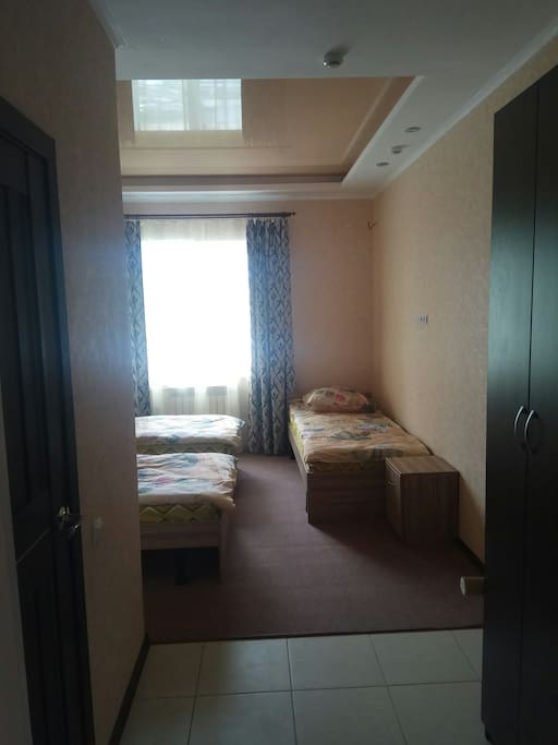 Room with 3 beds, shower, closet, drawers and toilet.
Комната с 3 кроватями, душевой кабиной, шкафом, ящиками и туалетом.