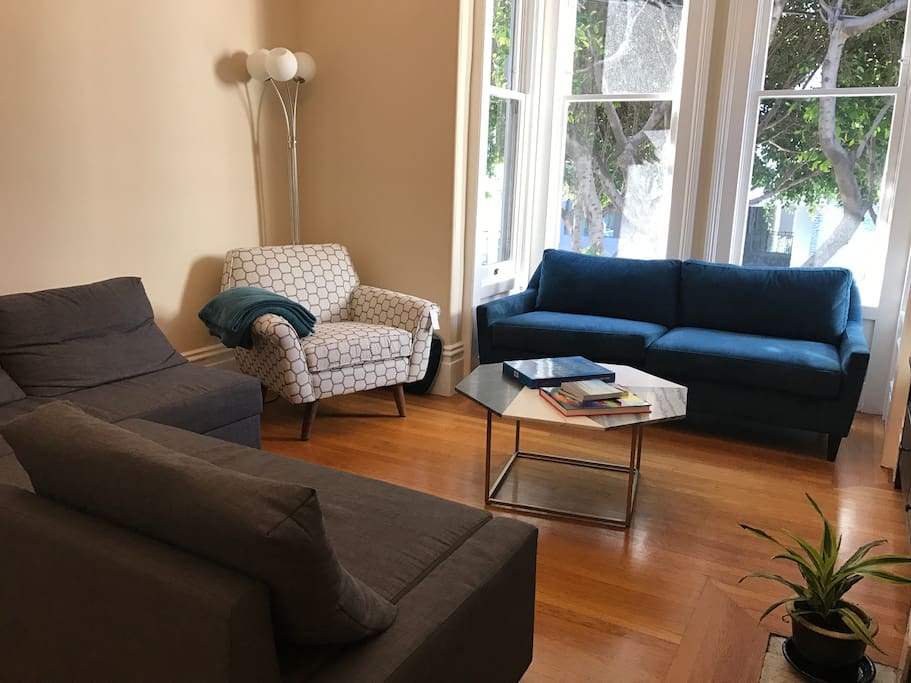 Bright and spacious living room with high ceilings and sofa bed