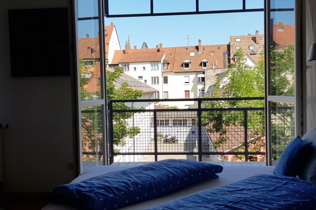 Blick vom Bett auf den hellen, ruhigen Innenhof. Morgens von der aufgehenden Sonne geweckt werden