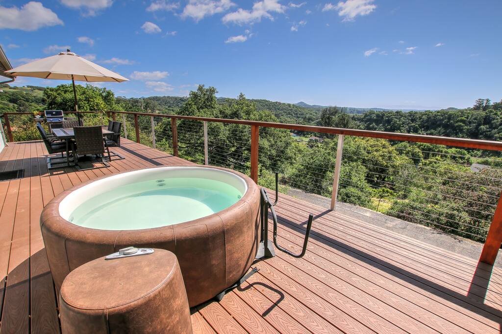 Large sun deck with a spa and outdoor dining