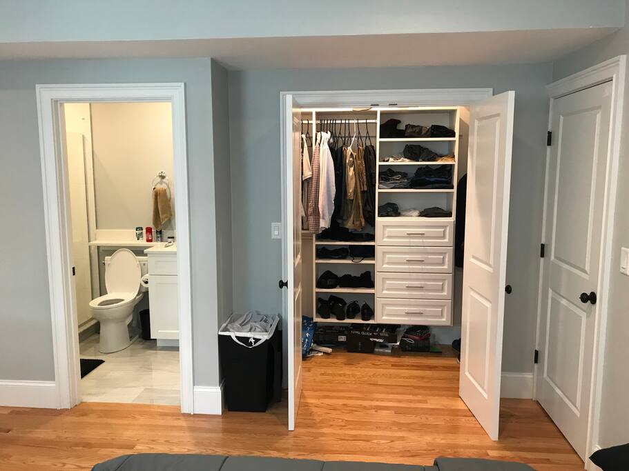 Full closet and bathroom with overhead shower